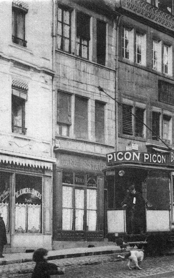 Au centre, un peu masquée par le tramway, la façade du café-restaurant de “Jo” Messmer (gros plan de la carte postale précédente).