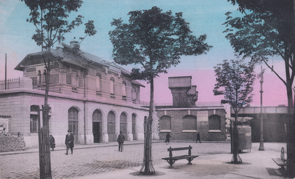 La gare de Clichy-Levallois dans les années 1920. L’inspecteur est arrivé par le pont ferroviaire, visible derrière l’urinoir, à droite. Carte postale colorisée, collection mémoire Vive.