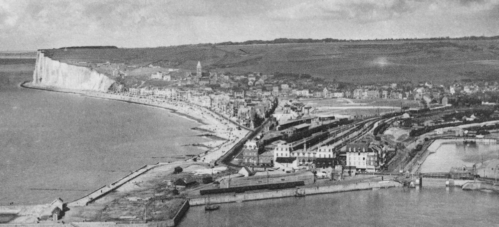 Le Tréport, Eu, la gare, avec une voie de desserte de marchandises longeant le port. Au fonds, la ville de Mers entoure sa prairie. Carte postale “voyagée” en 1935 (recadrée). Coll. Mémoire Vive.