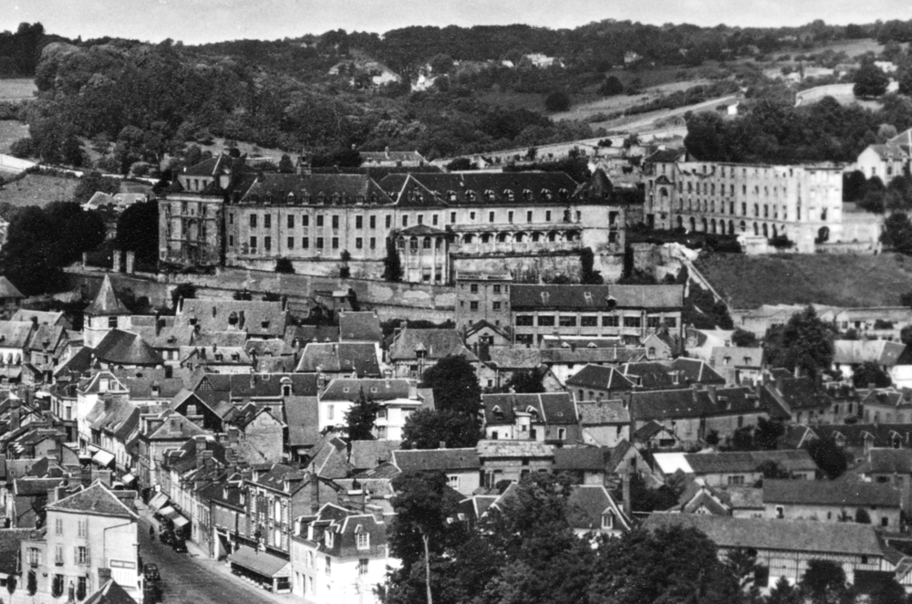 Le château de Gaillon, au-dessus du village. Les internés sont assignés au pavillon Colbert, le grand bâtiment isolé à droite (lequel a perdu sa toiture après la guerre) Carte postale des années 1950. Collection Mémoire Vive.