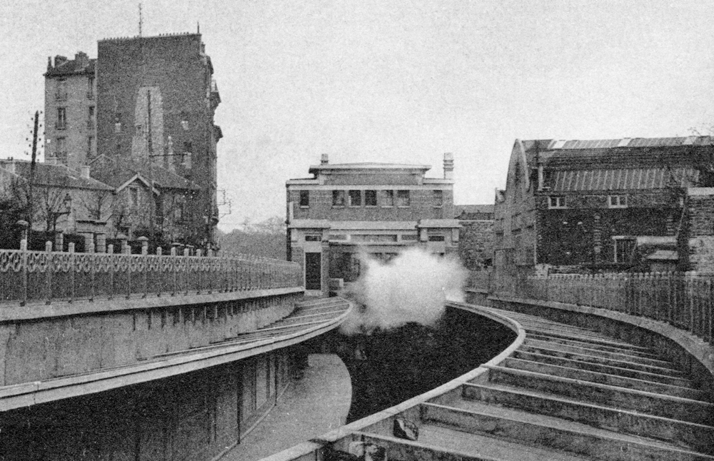 Gentilly. La station de la « ligne de Sceaux » (R.E.R. ligne B).. L’usine Sanders occupait le bâtiment visible à droite et qui existe encore aujourd’hui (2023). La fille de Marceau Baudu se souvient que son père lui faisait parfois signe par une lucarne quand elle prenait le train pour Paris sur le quai situé à gauche en contrebas. Carte postale oblitérée en 1935. Collection Mémoire Vive