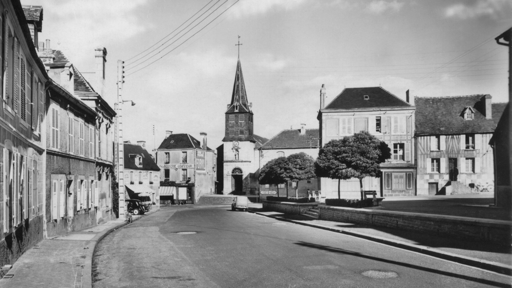 Mézidon. La rue Émile Zola et l’église. Carte postale “voyagée” après guerre. collection Mémoire Vive.