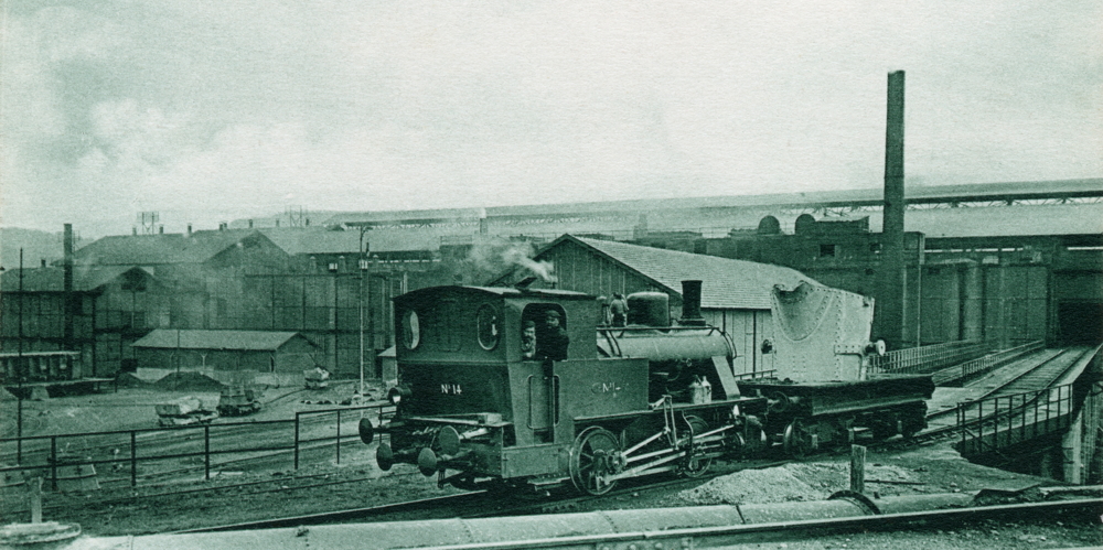 Usine de Neuves-Maisons. Poussée par la locomotive, une « poche amenant la fonte des fourneaux au mélangeur ». Carte postale des années 1900. Collection Mémoire Vive.