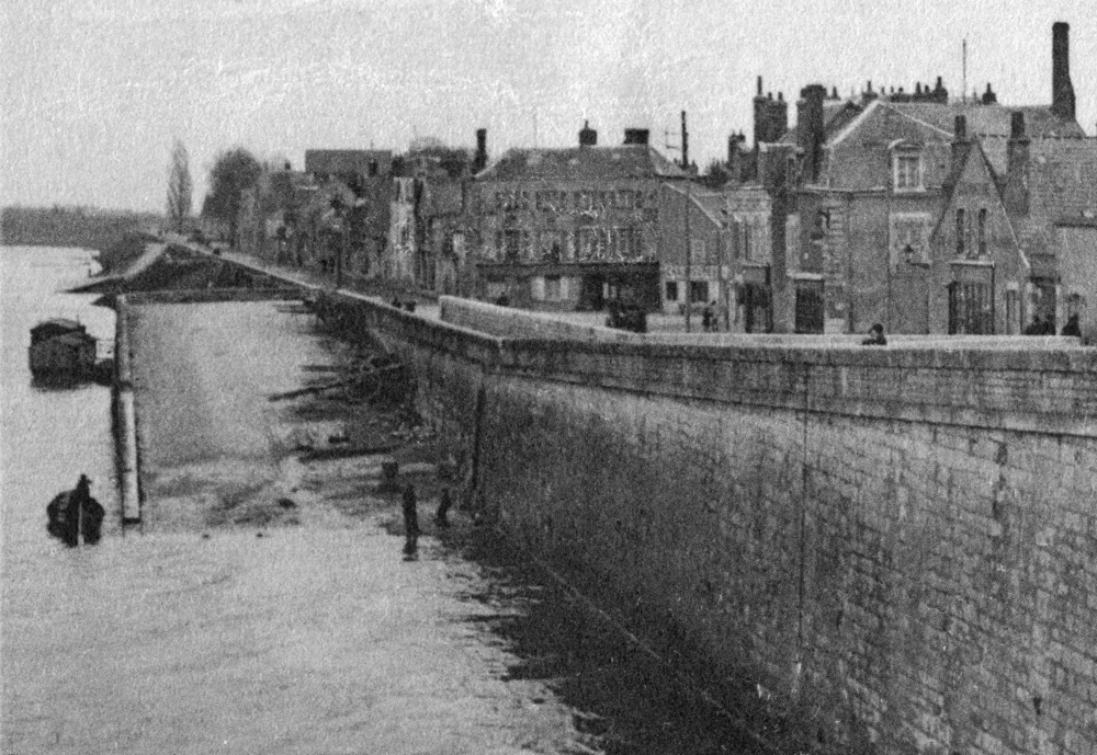 Orléans. Le quai des Augustins, vu depuis le pont Georges V, dans les années 1910. Au centre, le petit immeuble abritant le café en son rez-de-chaussée. Carte postale (recadrée), collection Mémoire Vive.