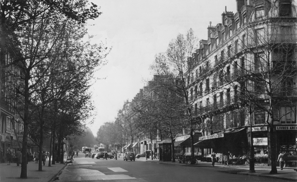 Paris. Le bas du boulevard Saint-Michel ; on devine le carrefour avec le boulevard Saint-Germain. À droite, la librairie de Paul Boulinier. Carte postale “voyagée” en 1950. Collection Mémoire Vive.