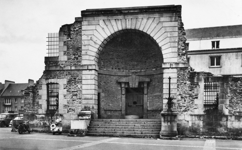 Saint-Lô, chef-lieu de la Manche, la porte de la prison ; tout ce qu’il en reste après les bombardements alliés de la Libération, notamment celui du 6 juin 1944, qui y tua de nombreux de résistants détenus. Carte postale des années 1950. Collection Mémoire Vive.