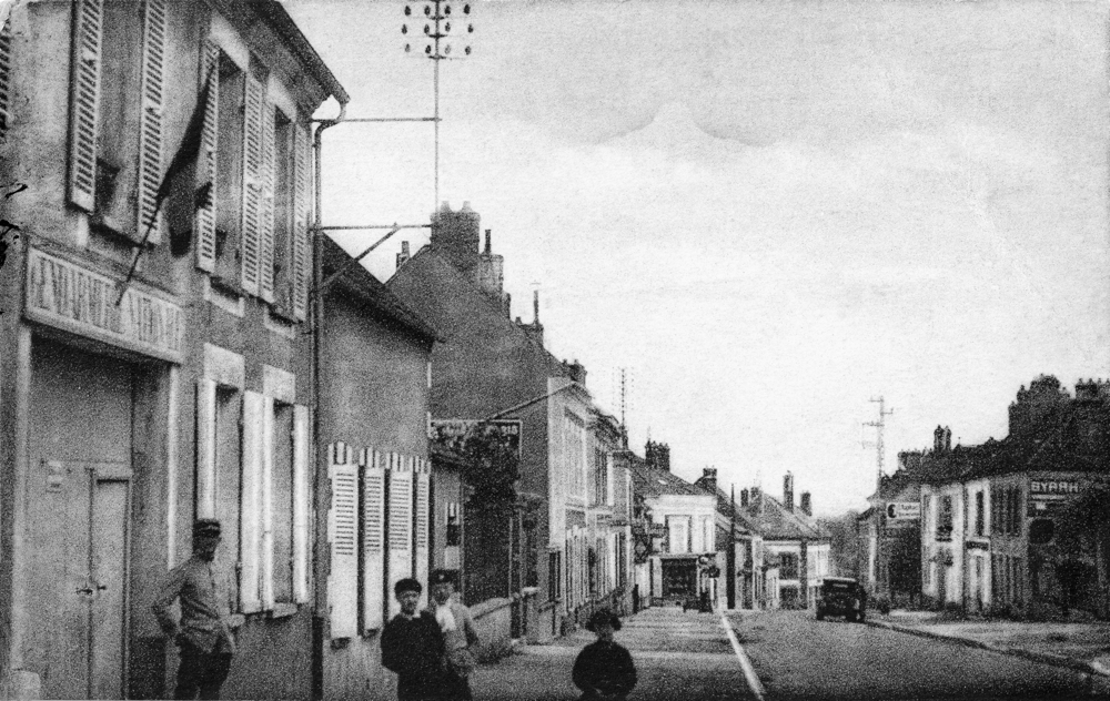 Villeneuve-la-Guyard, la rue de Paris. À gauche, la gendarmerie. Cette brigade a-t-elle participé à l’arrestation de Maurice Dadé ? Carte postale éditée à une date inconnue. Collection Mémoire Vive.